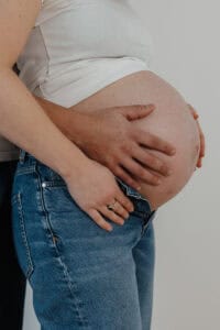 Inniger Moment werdender Eltern, festgehalten in einer entspannten Atmosphäre.