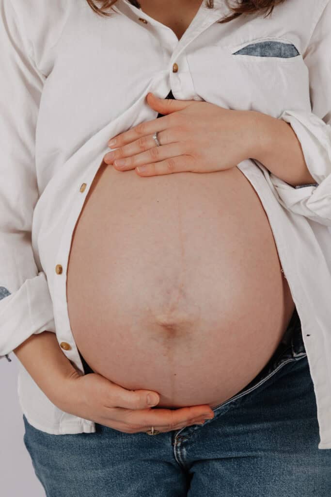 Babybauch Fotos Hamburg Studio – Detailaufnahme des Babybauchs mit Händen