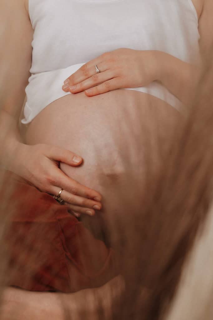 Babybauch Mini Shooting Hamburg im Studio – Detailaufnahme mit warmem Licht