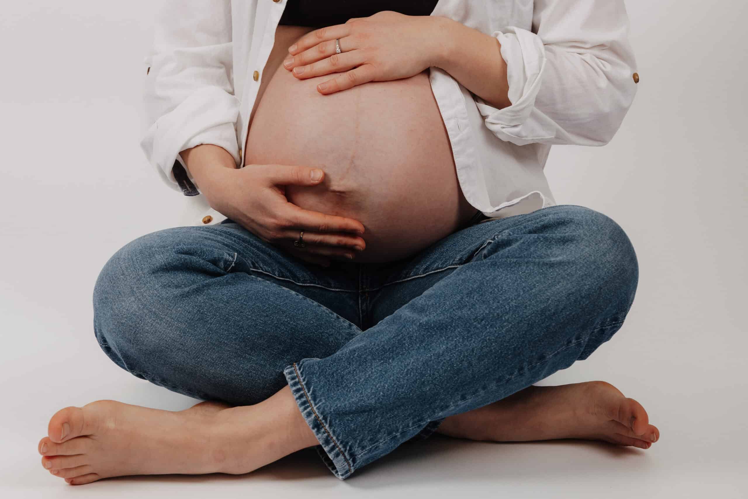 Babybauch Shooting Hamburg Studio – Schwangere sitzt entspannt auf dem Boden